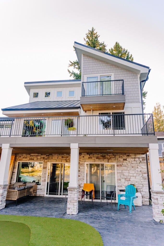 horizontal steel rod railing on grey composite decking with siding on house