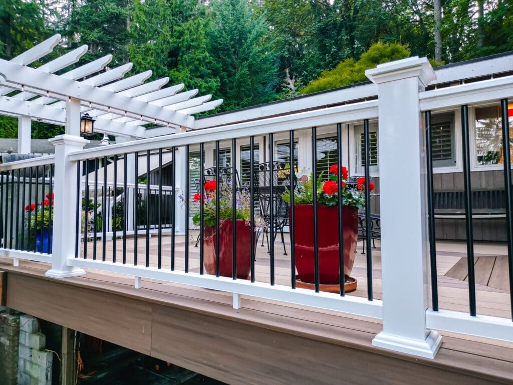 Vertical surface mount black post white rail composite railing with pergola