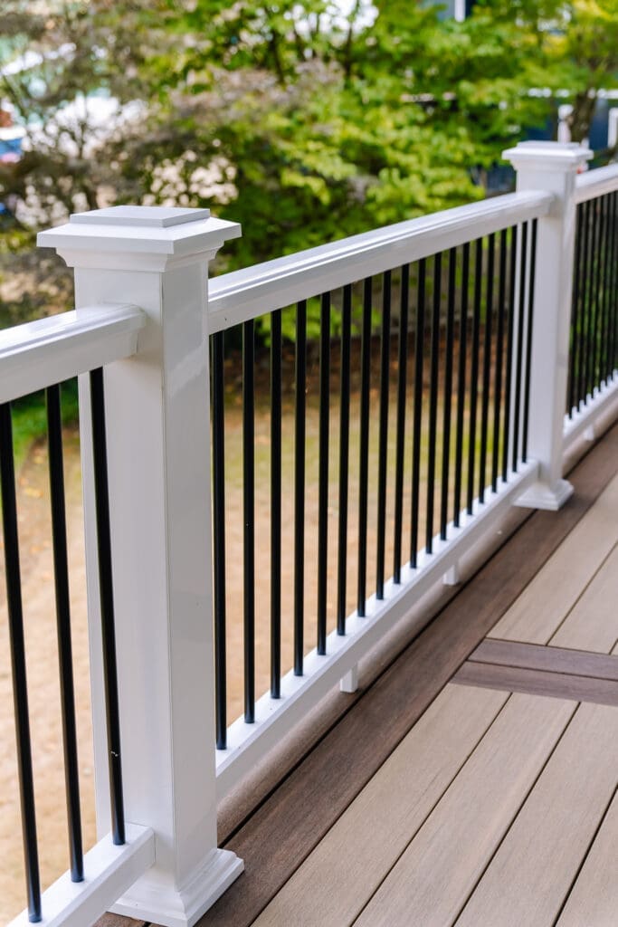 Vertical surface mount black post white rail composite railing