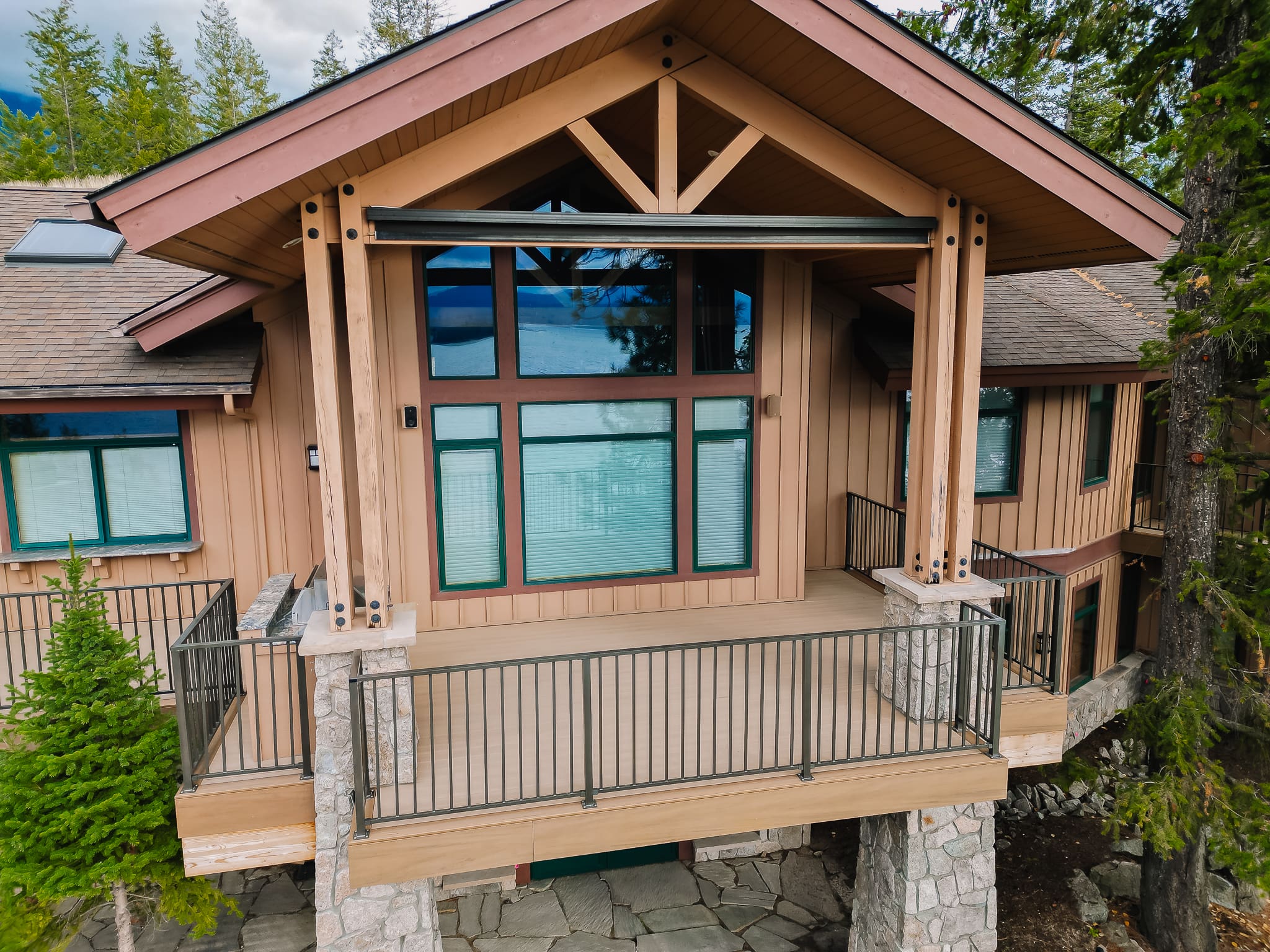 Modern wooden cabin with weathered teak azek balcony and large windows.
