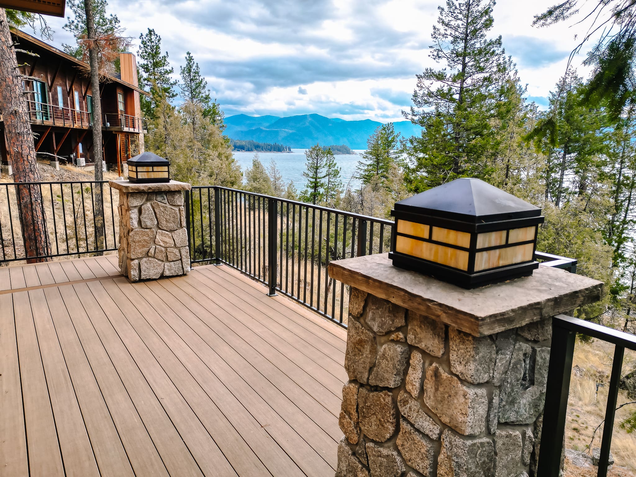 Scenic lake view from azek weathered teak deck with stone pillars.