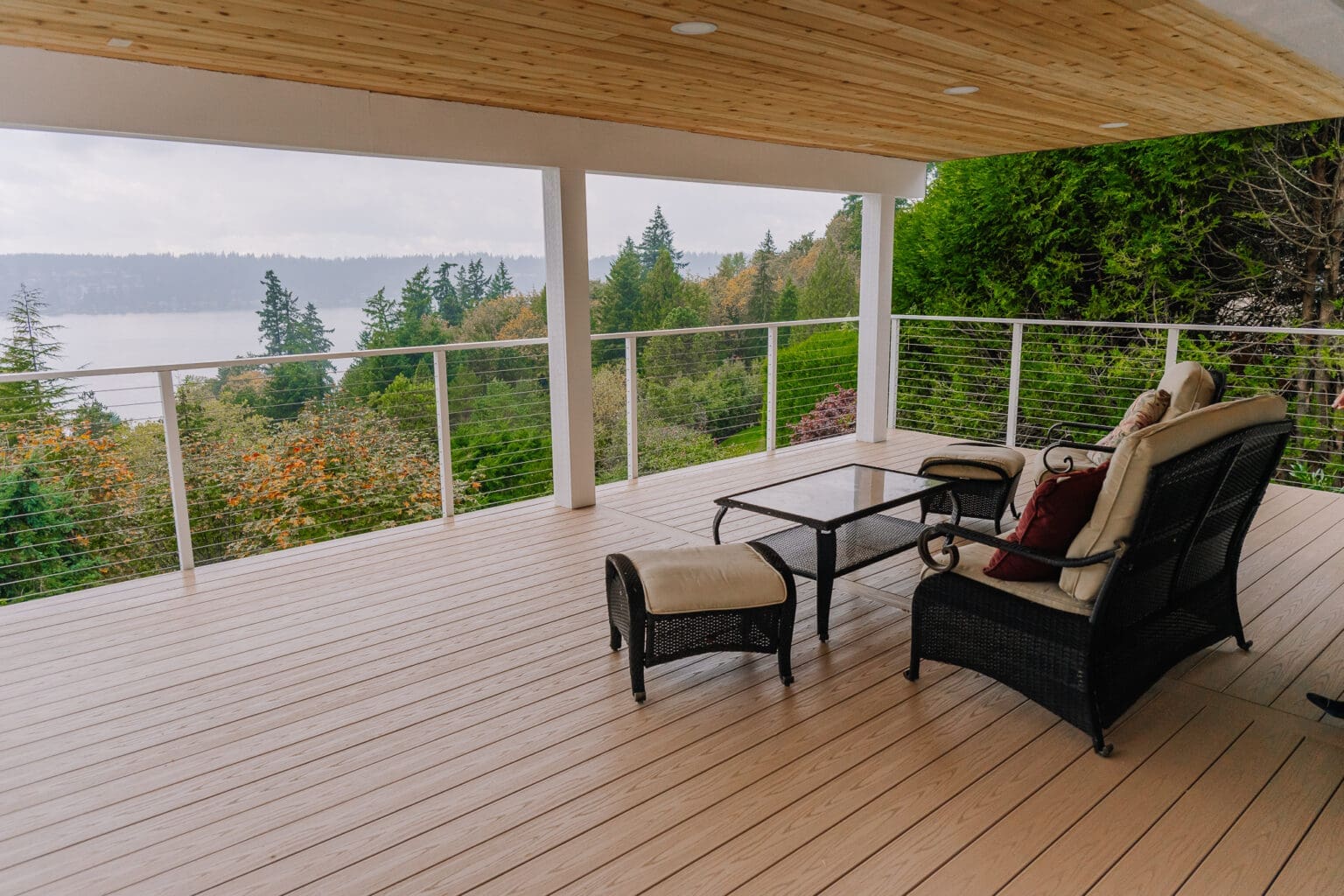 Covered balcony with seating and forest view maisy railing