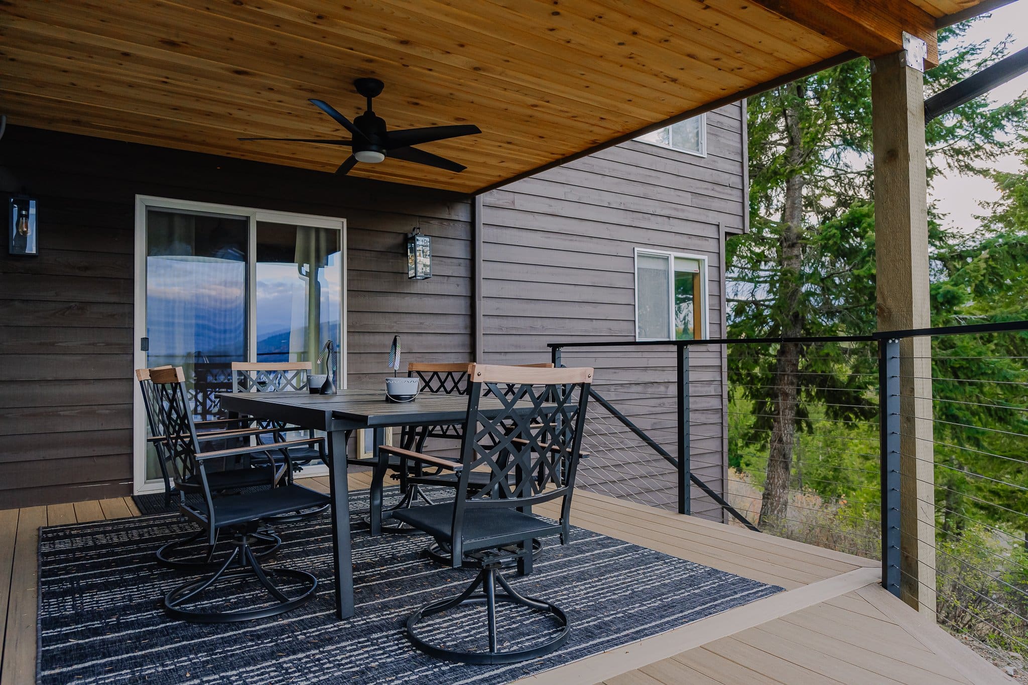 Outdoor patio with modern dining furniture, cedar soffit, outdoor fan