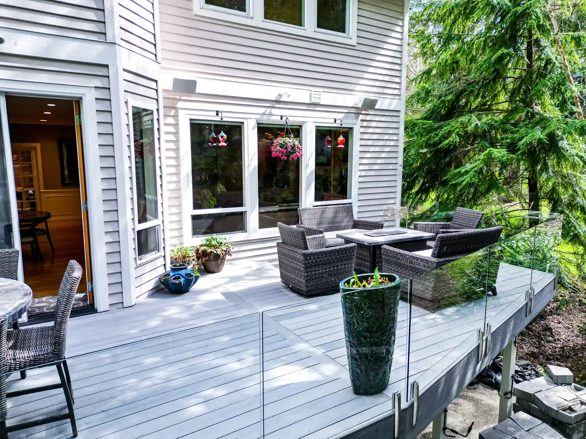 Modern patio with wicker furniture and glass railing.