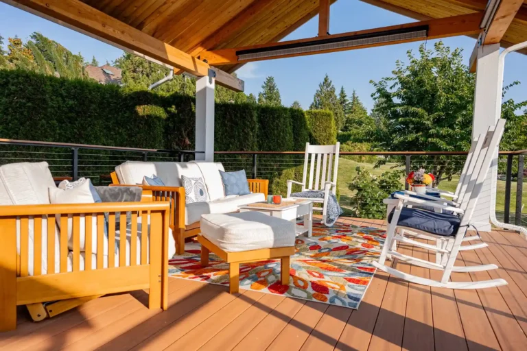 Cozy patio with outdoor furniture and colorful rug.