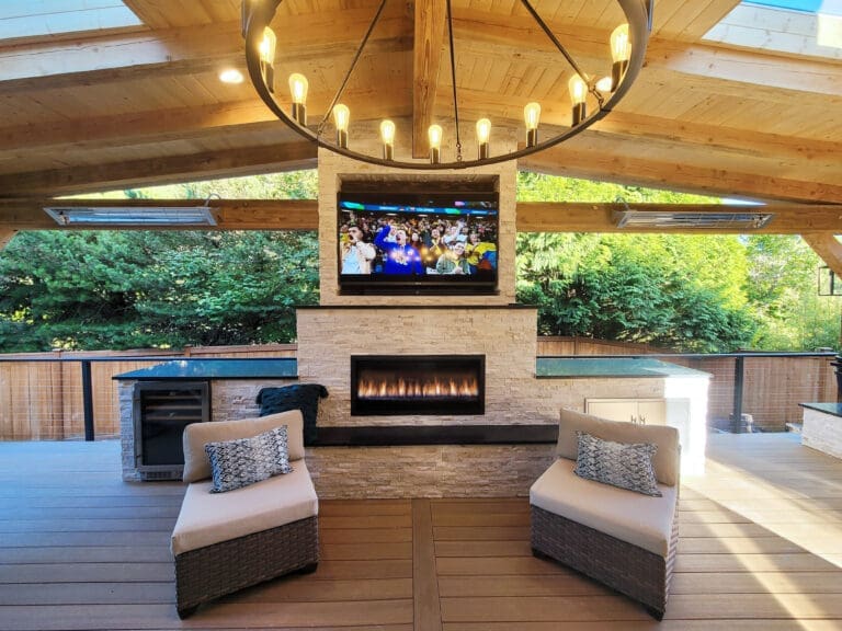 Outdoor patio with fireplace and TV under pergola.