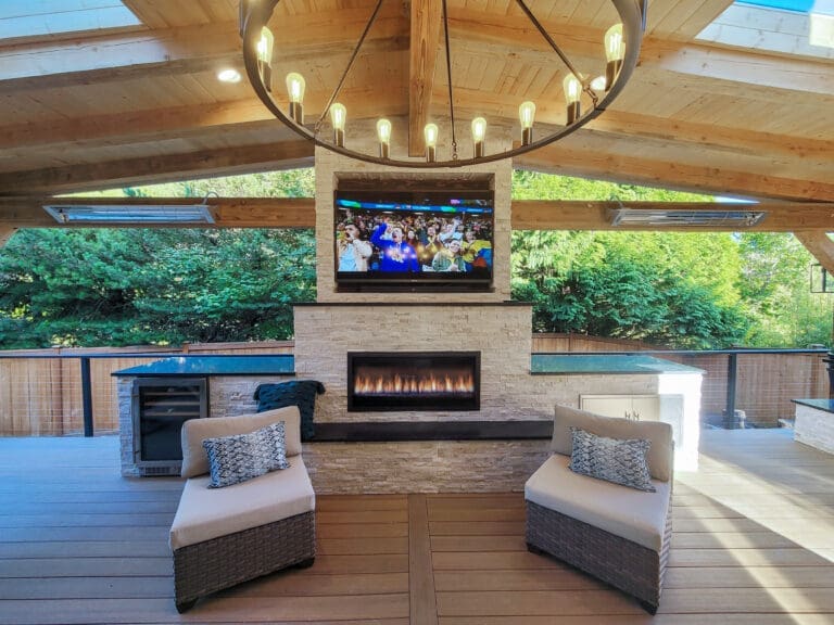 Outdoor covered patio with fireplace, TV, and seating area.