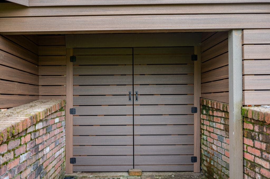 Wooden shed door with brick walls around.