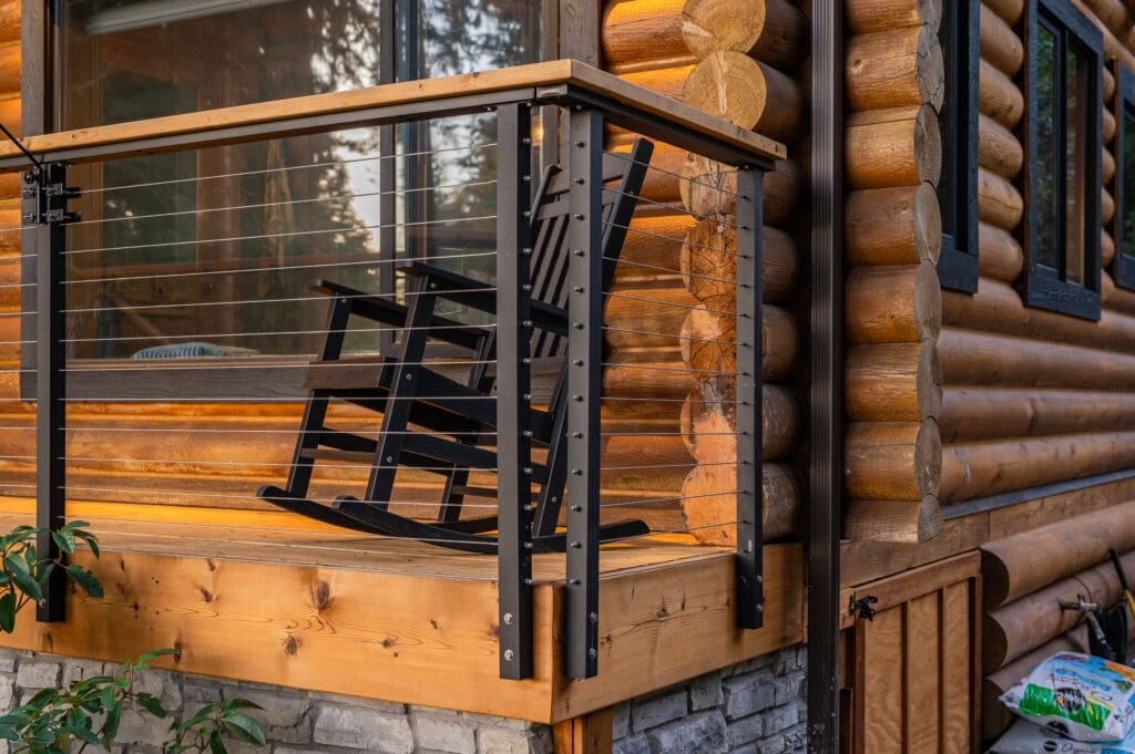 Black rocking chair on log cabin deck.