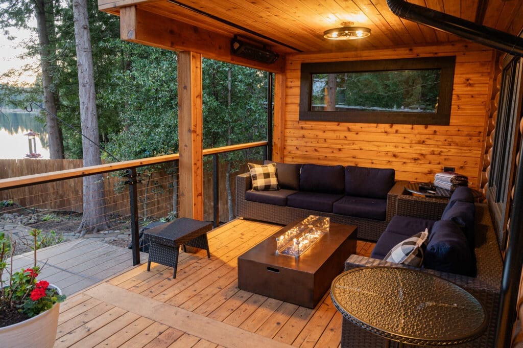 Cozy wooden deck with seating and a fire table.