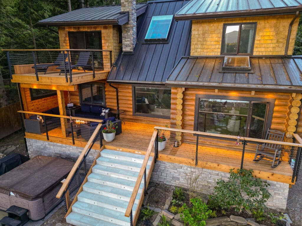 Modern log cabin with upper deck and patio.