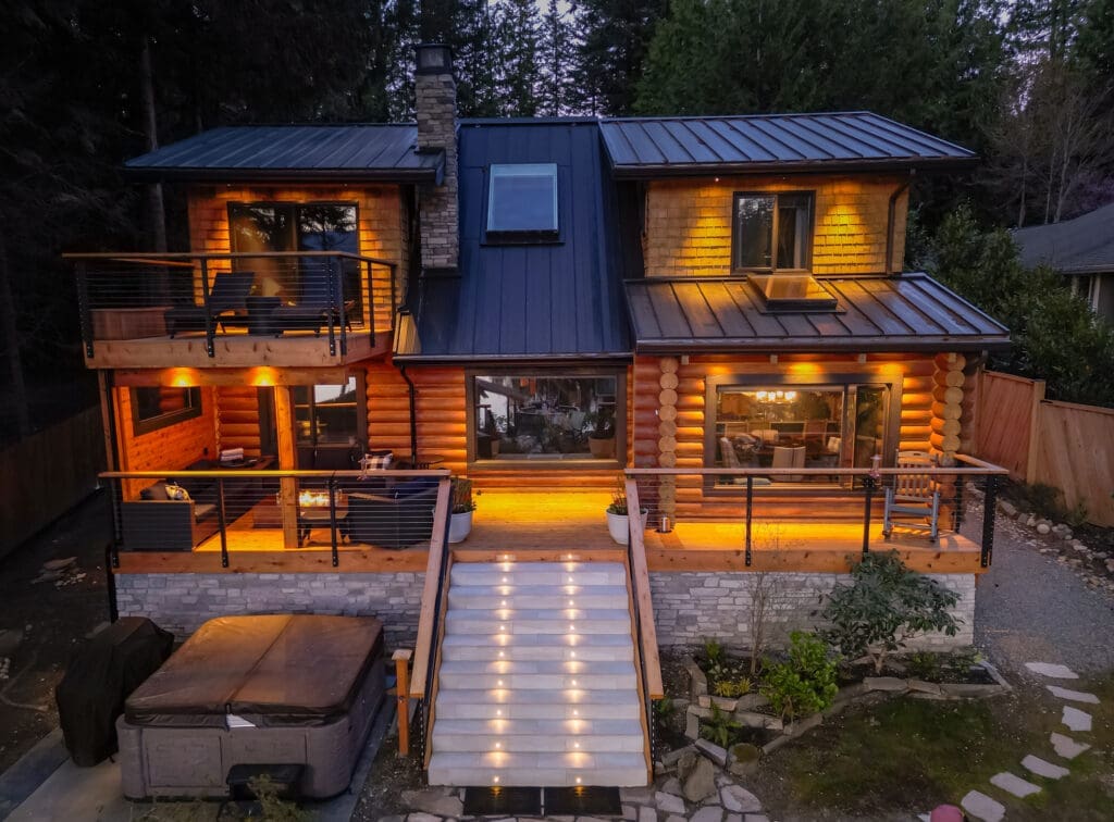 Cozy log cabin with warm outdoor lighting at dusk.