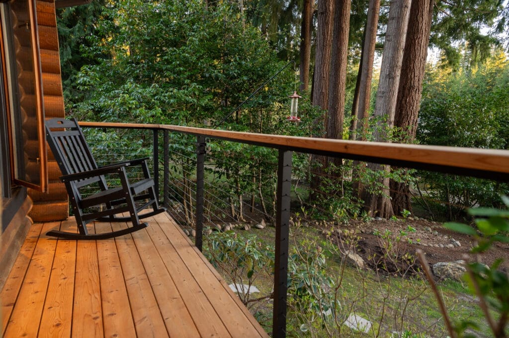Wooden porch with rocking chair and forest view.