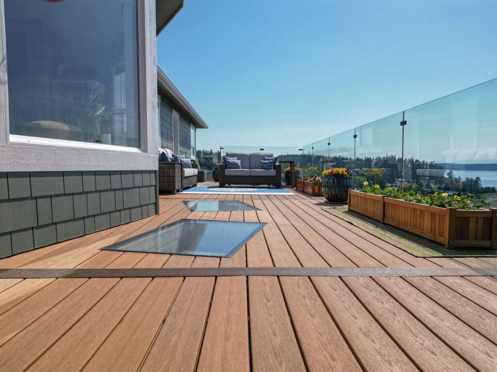 Spacious deck with glass railing and ocean view.