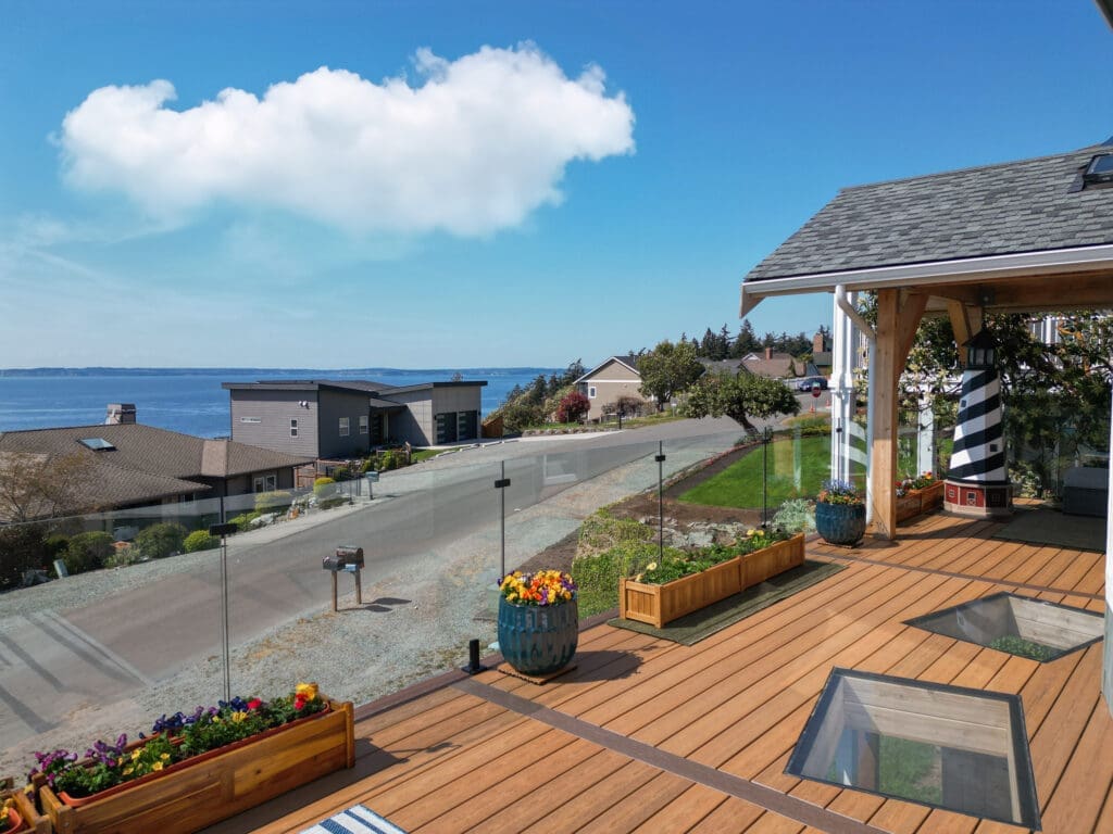 Coastal view from modern patio with glass railing.