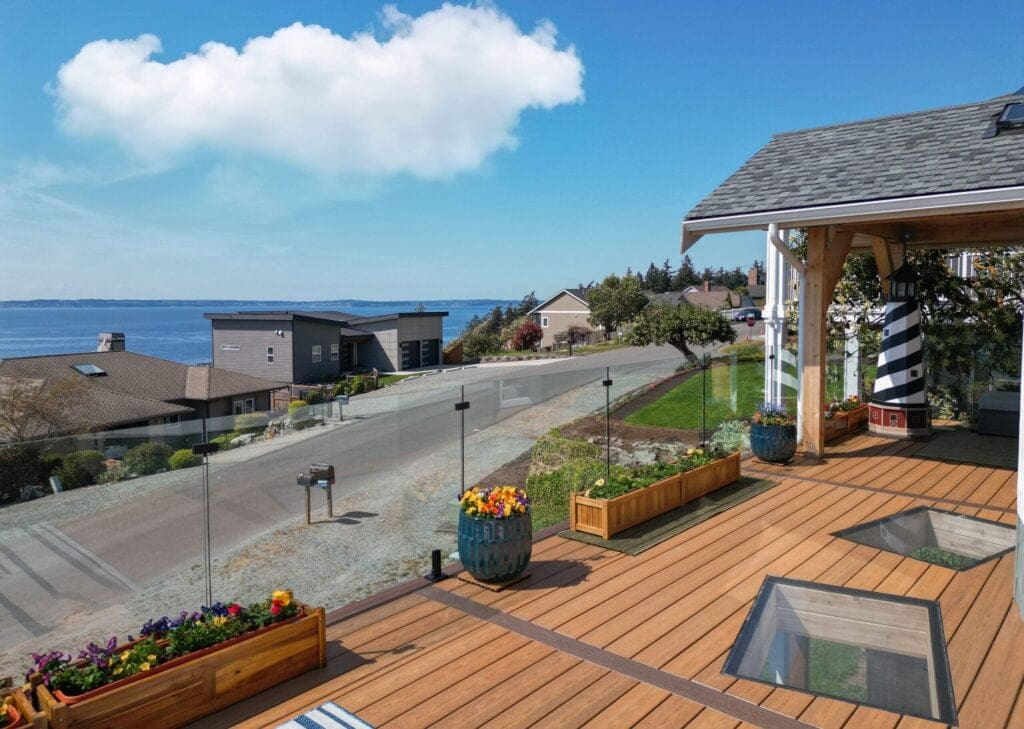 Coastal view from modern patio with glass railing.