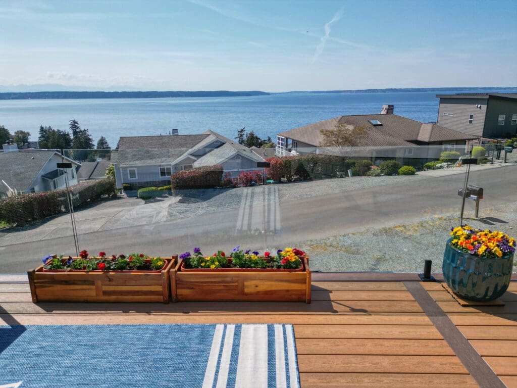 Deck with ocean view and colorful flowers.