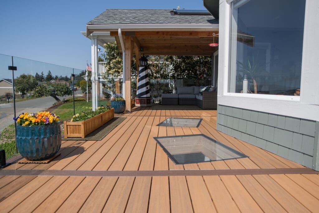 Modern patio with glass railing and seating area.