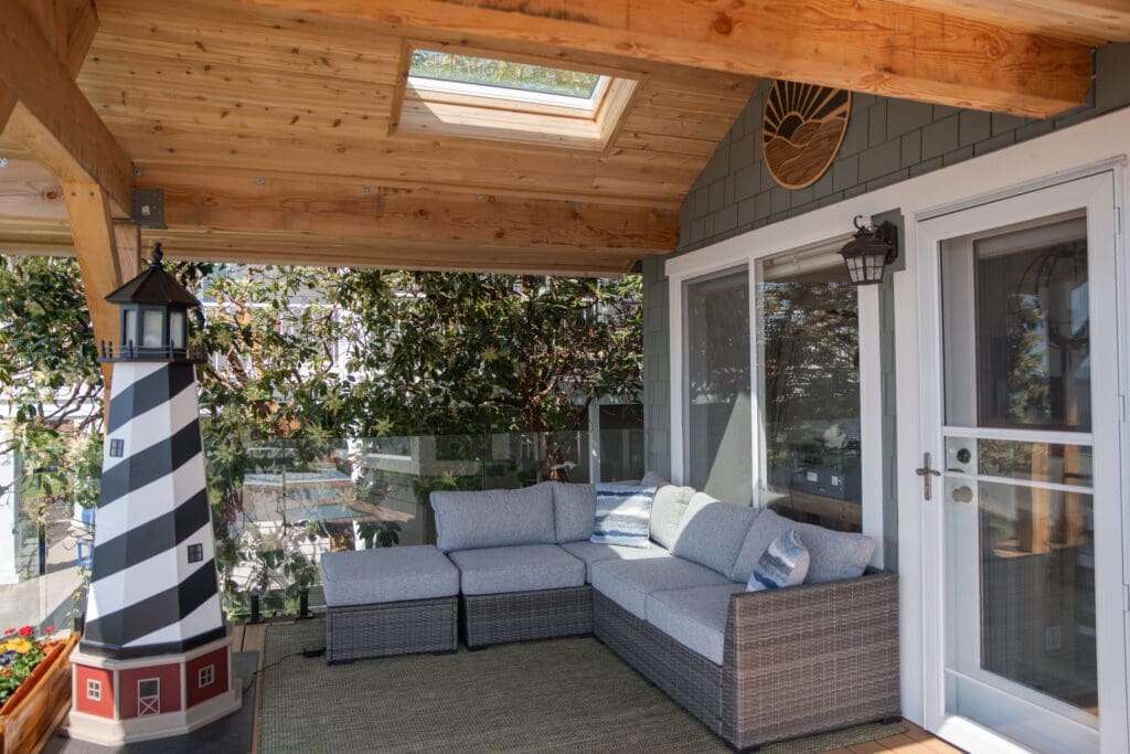 Cozy patio with wicker sofa and lighthouse decor.