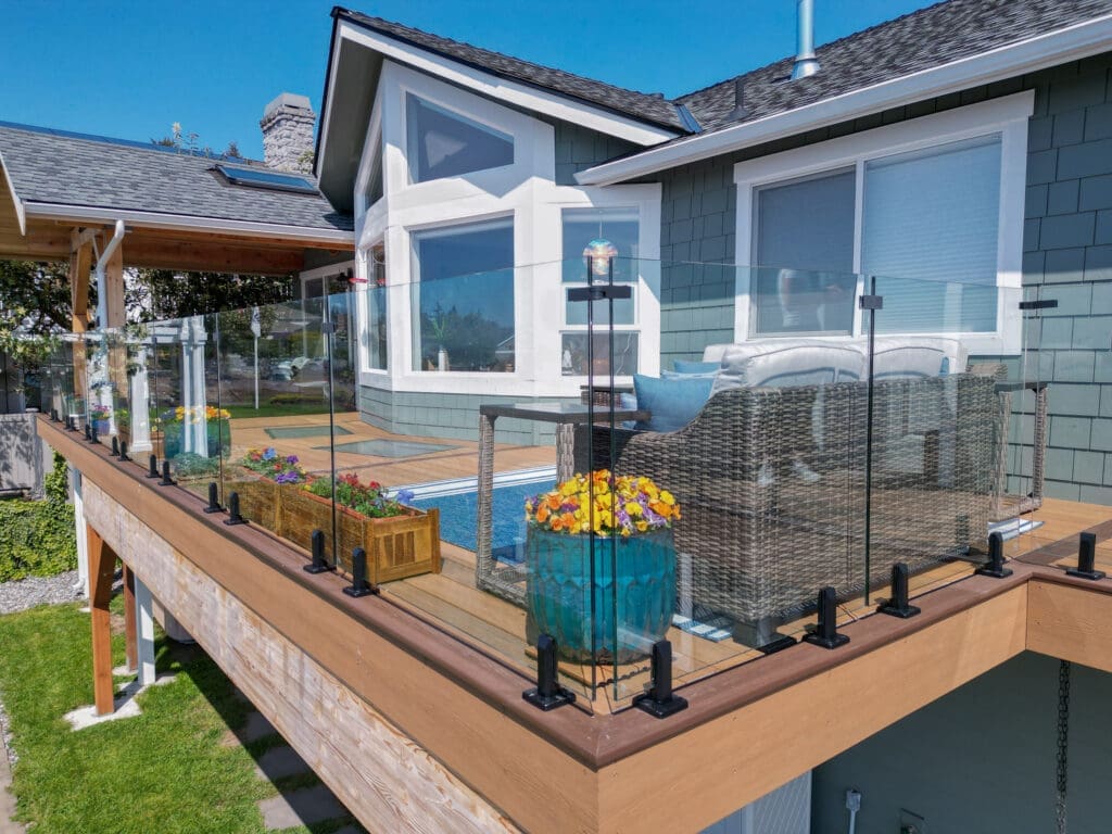 Modern deck with glass railing and outdoor seating.