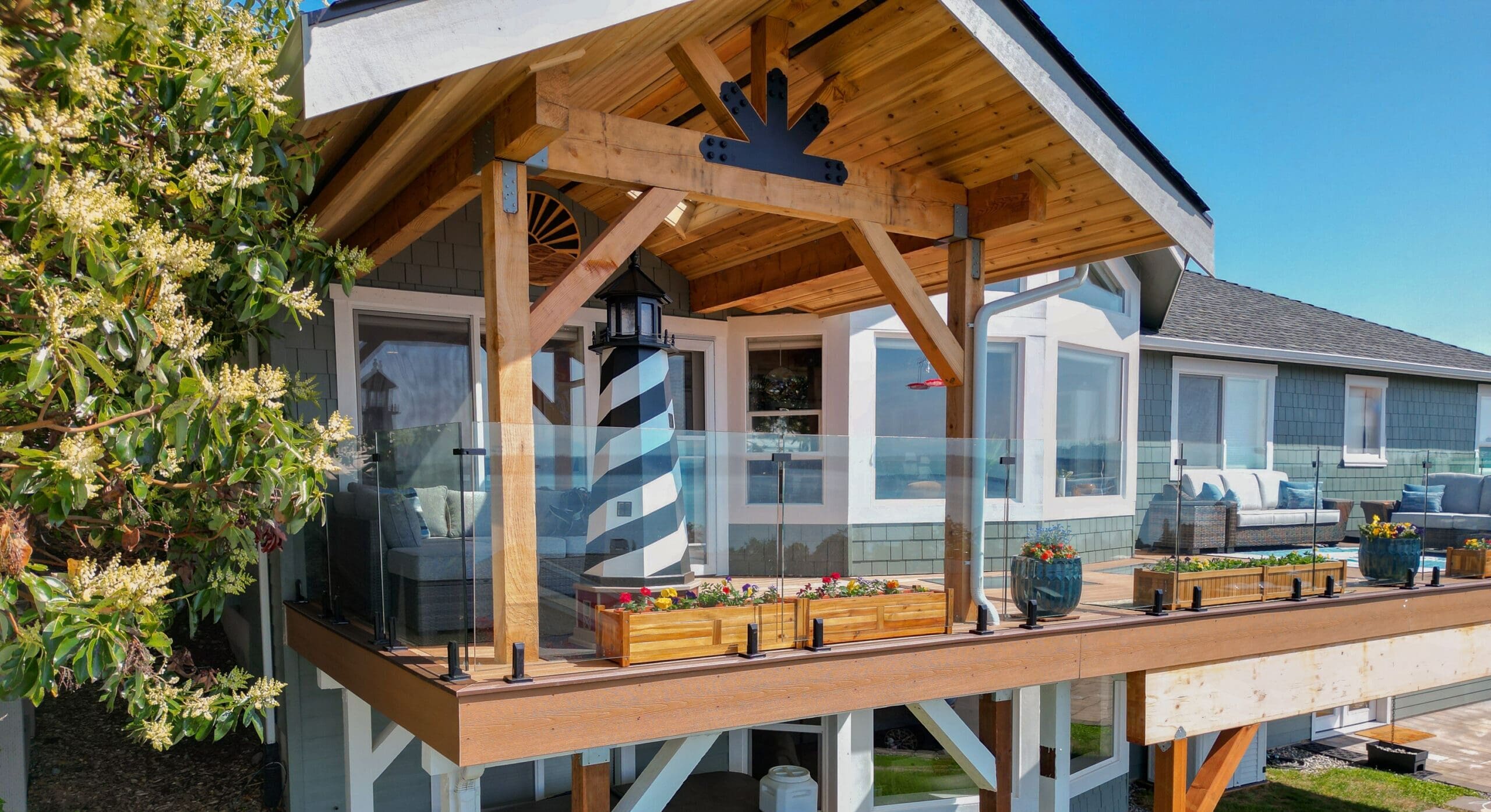Modern house with wooden deck and glass railing.
