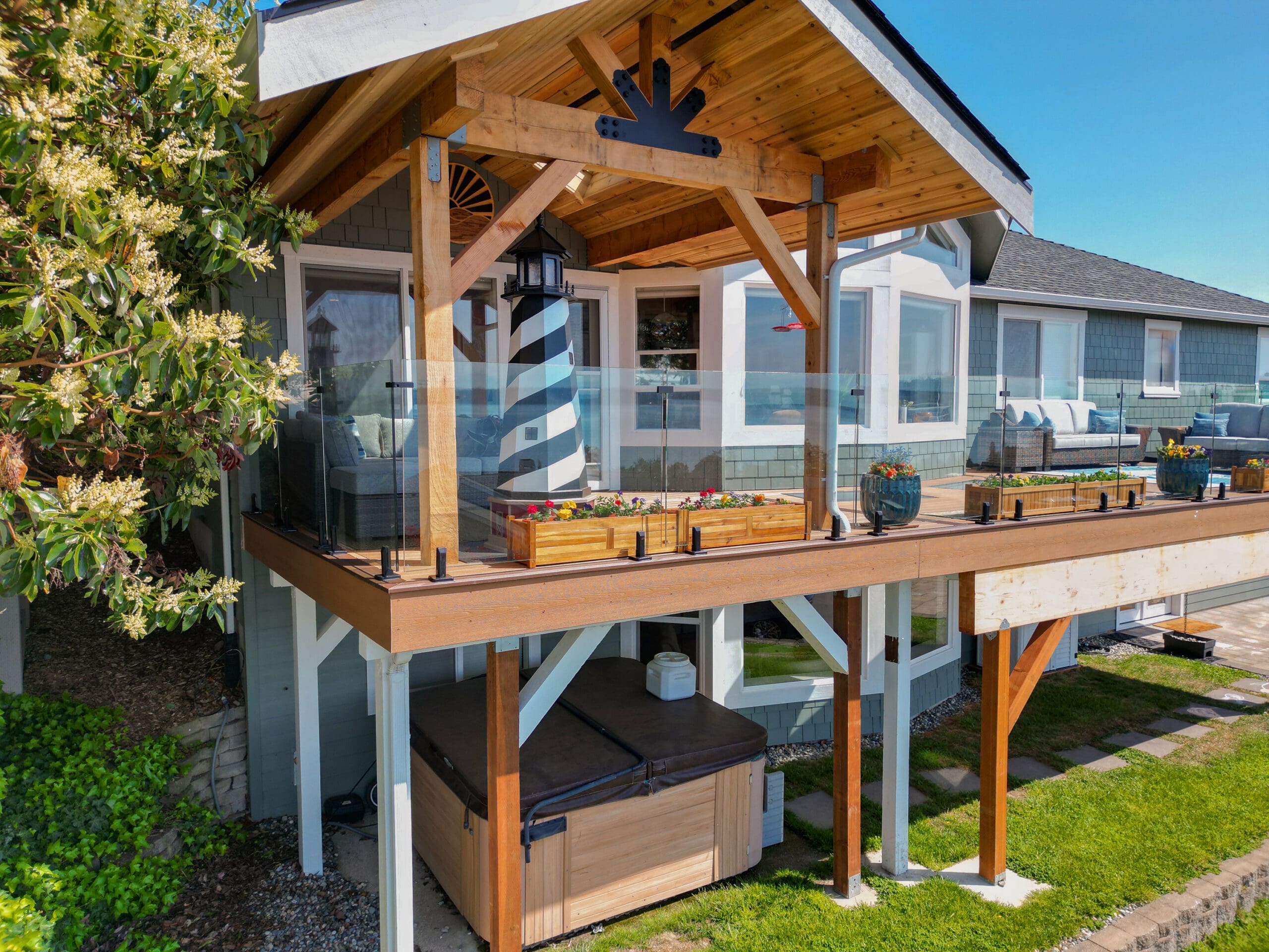 Modern house with wooden deck and glass railing.
