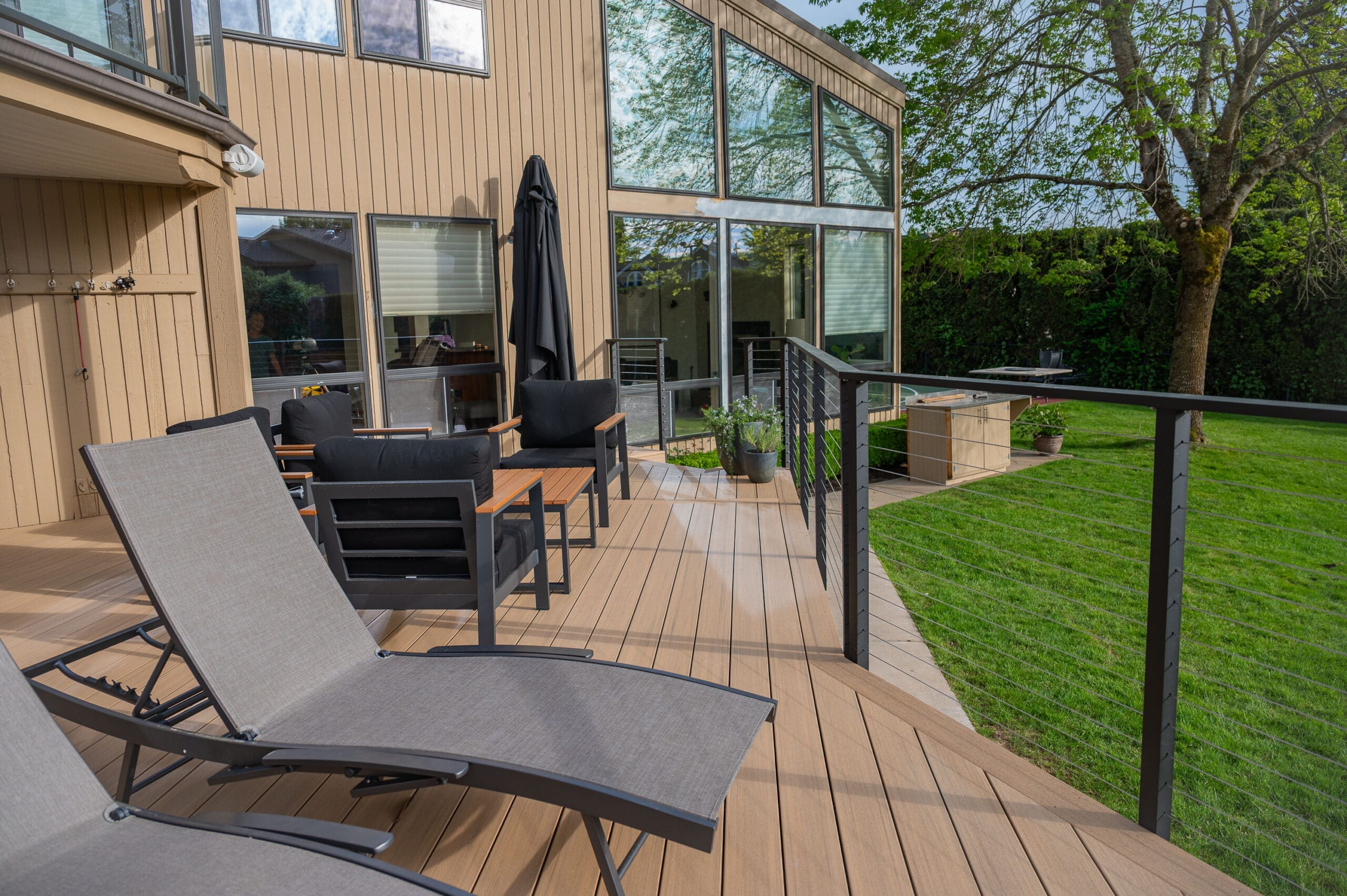 Modern wooden deck with seating and greenery.