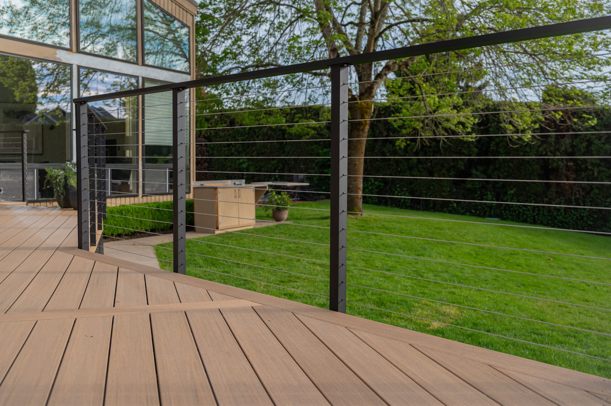 Modern deck overlooking lush green backyard.