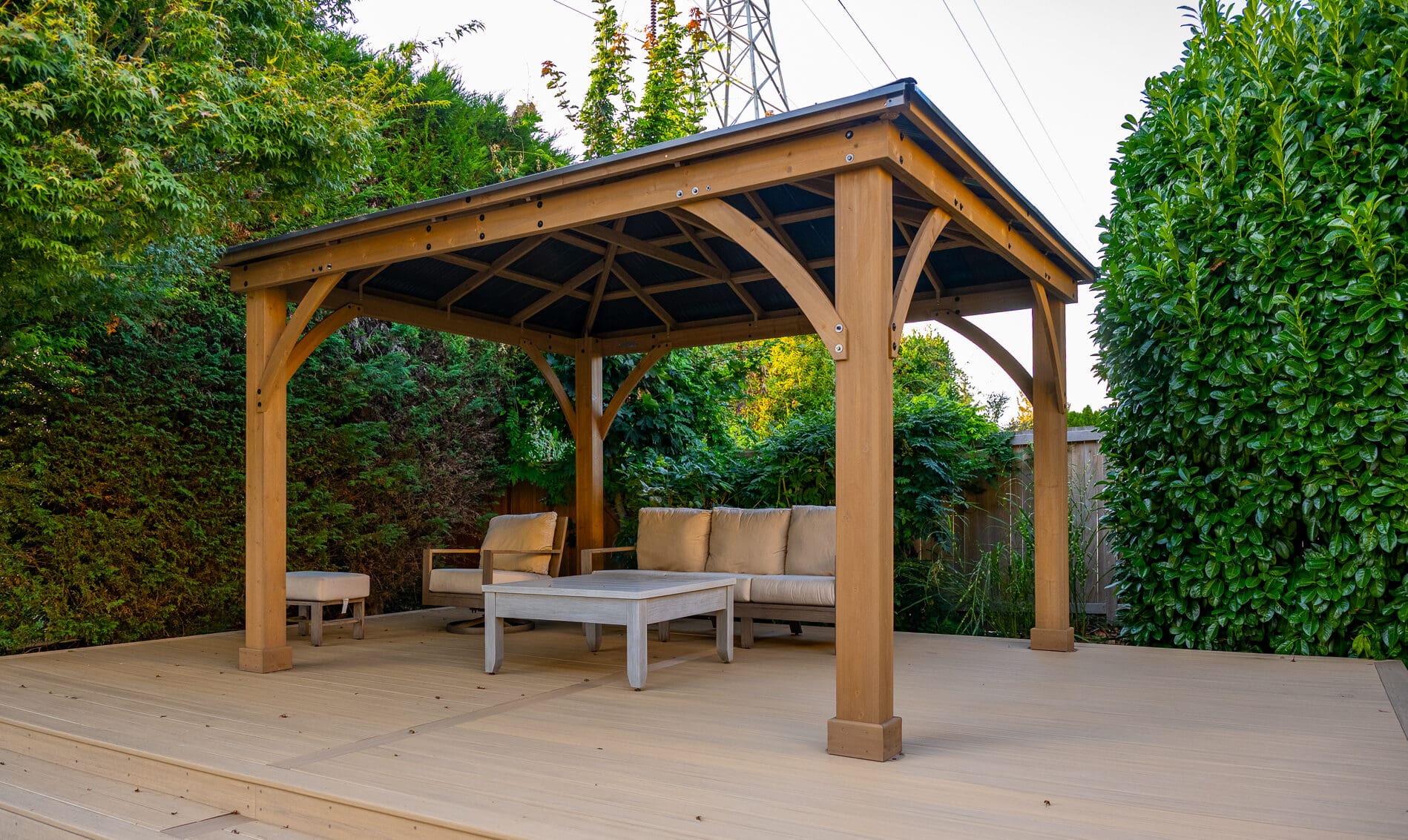 Wooden gazebo with seating on patio.