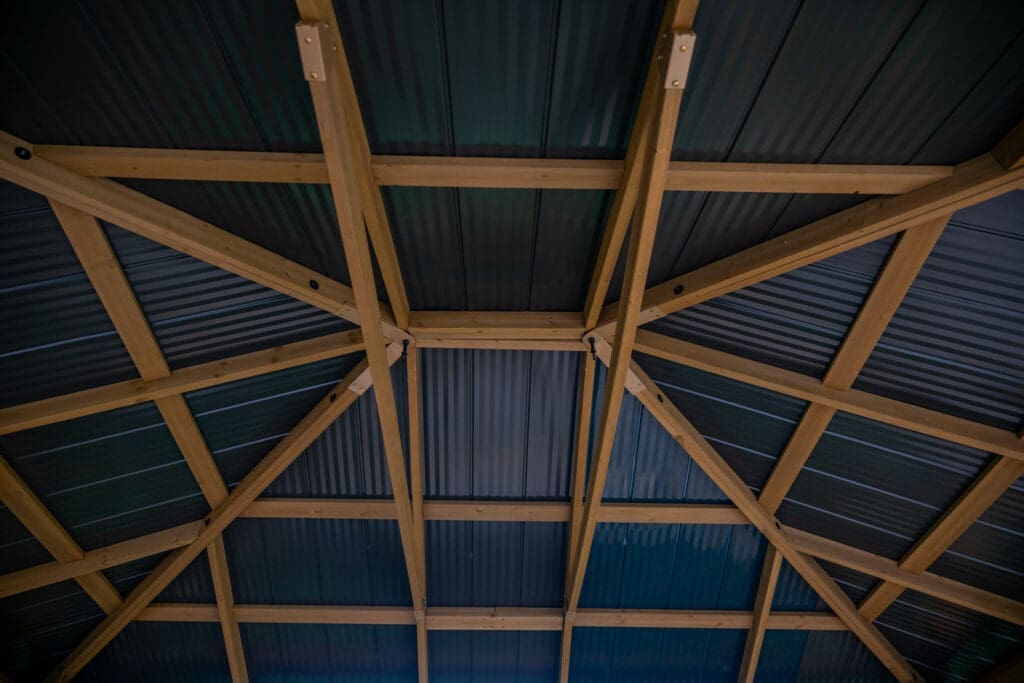 Wooden roof trusses with corrugated metal sheets.