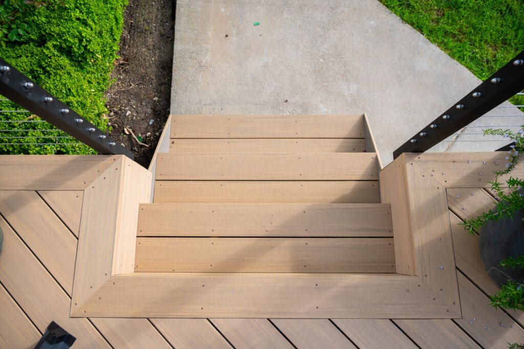 Wooden deck stairs leading to concrete walkway