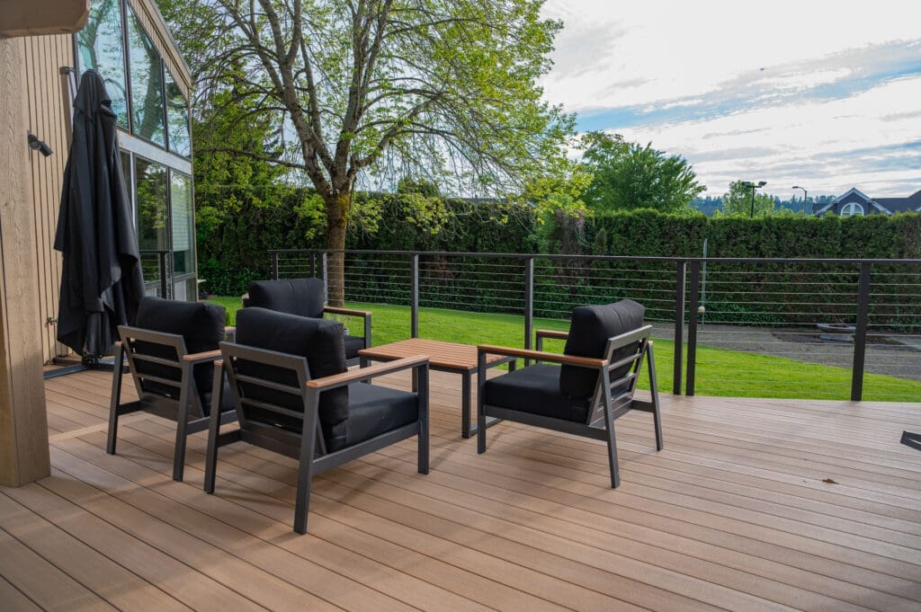 Modern backyard deck with black cushioned chairs