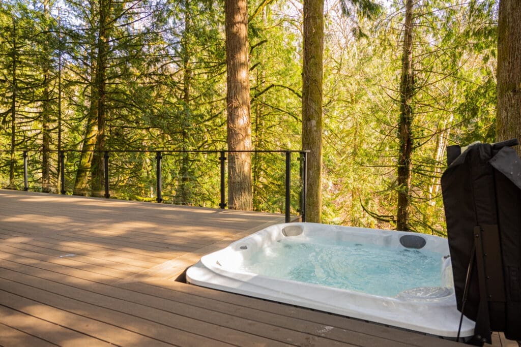 Hot tub on wooden deck overlooking forest