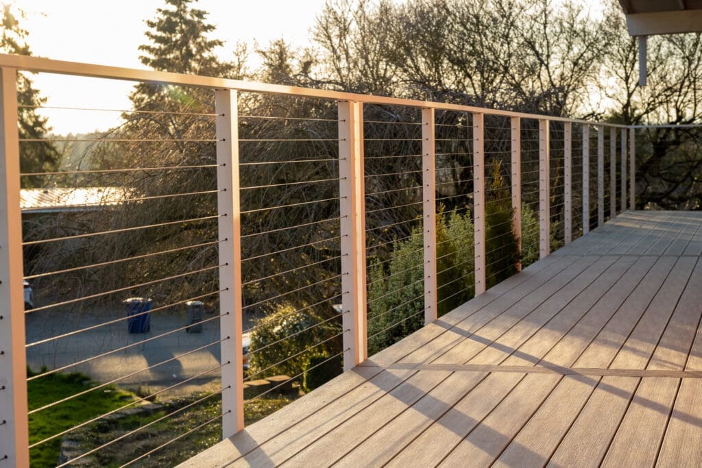 Modern wooden deck with cable railing at sunset