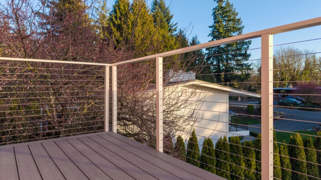 Modern balcony with cable railing overlooking neighborhood trees