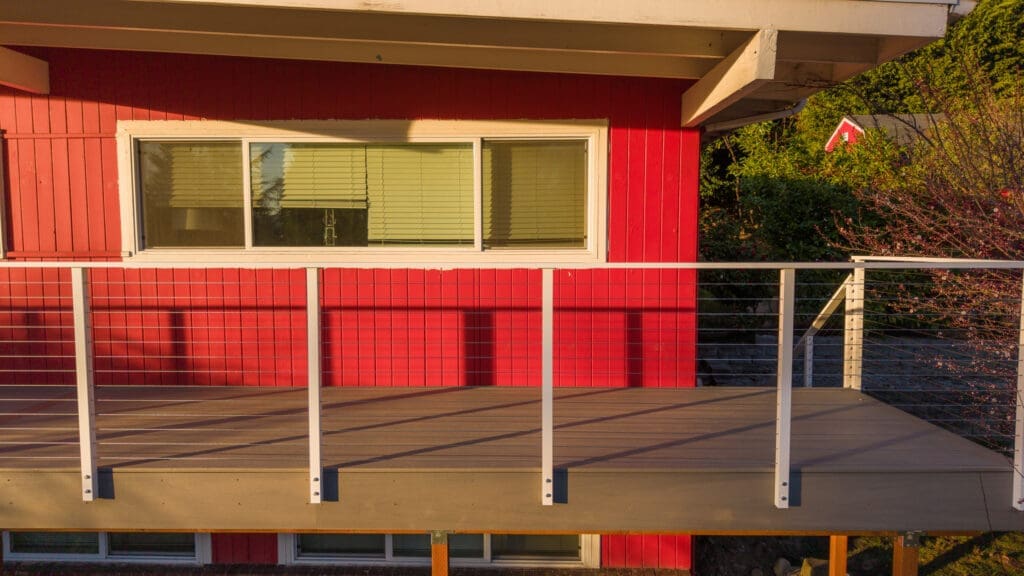 Red house exterior with wooden deck and railing