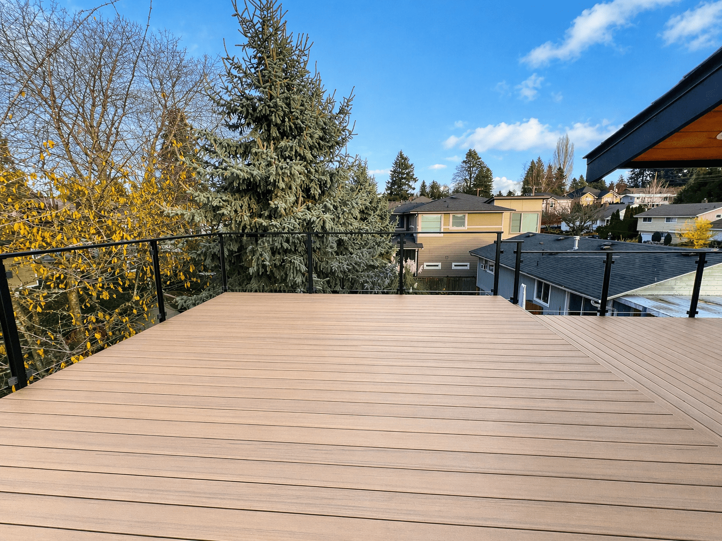 Modern backyard deck with glass railing and neighborhood view