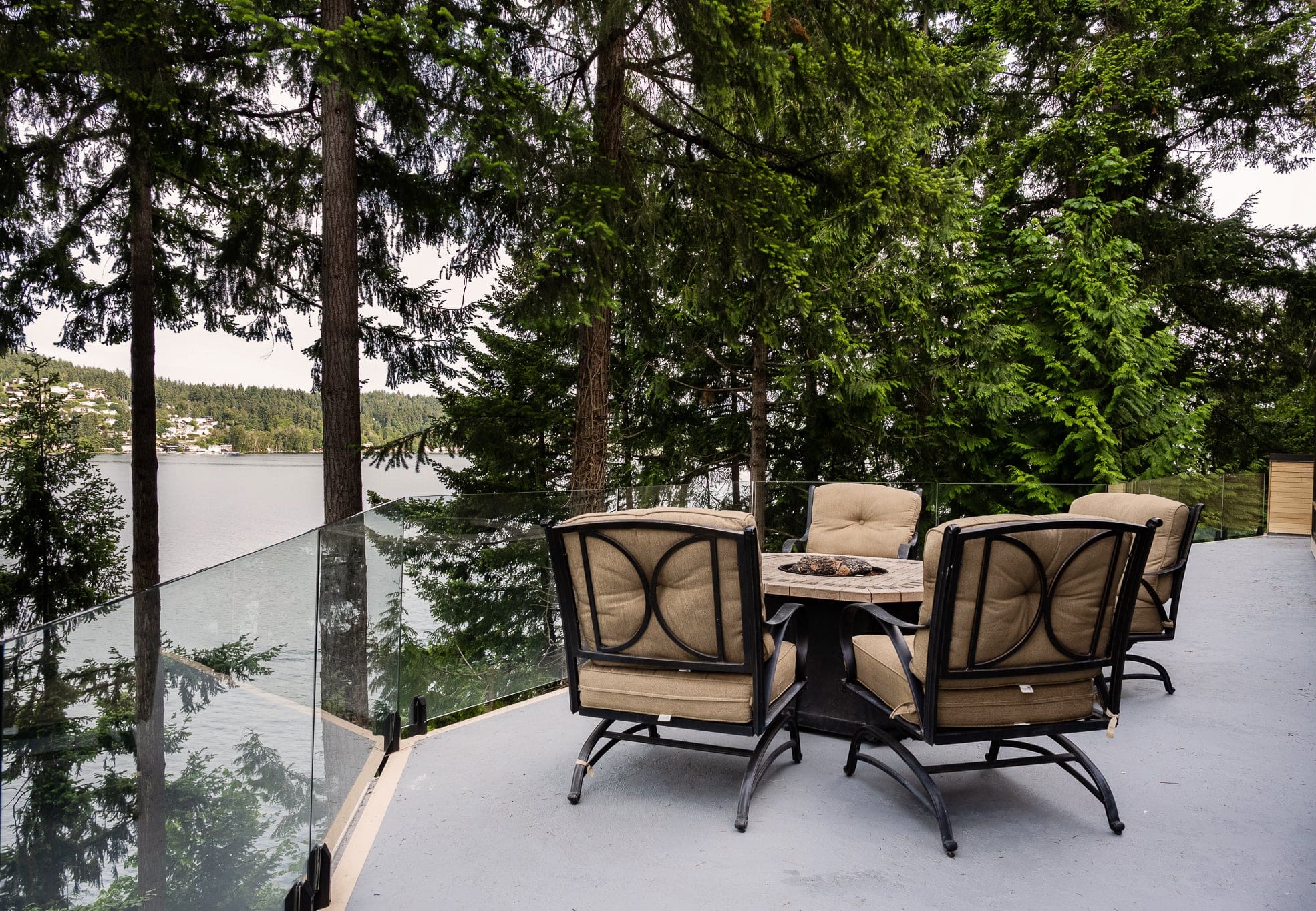 Lakeside deck with chairs and forest view