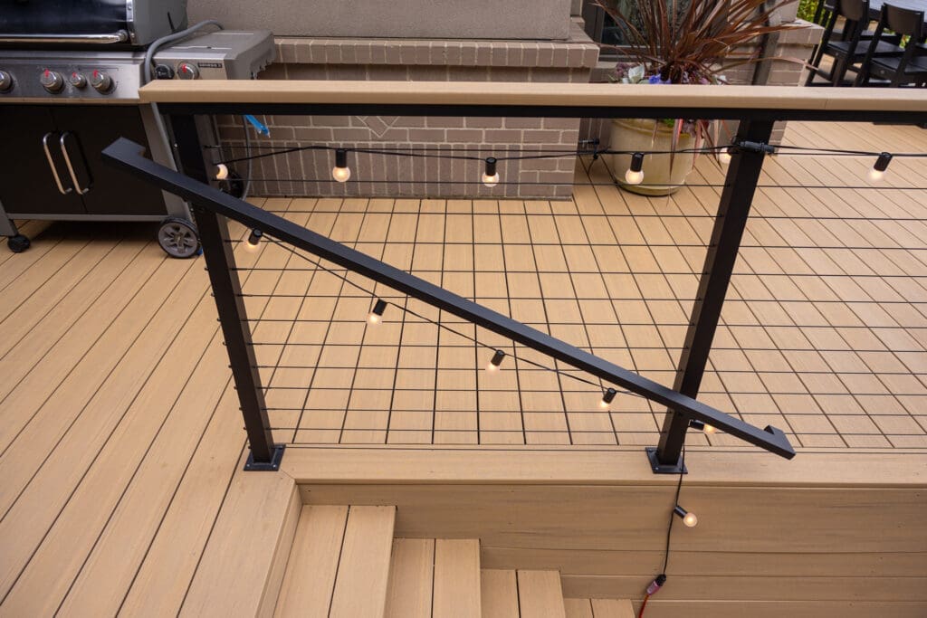 Deck railing with string lights and stairs