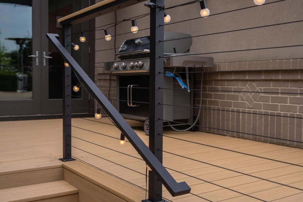 Modern deck railing with string lights and grill